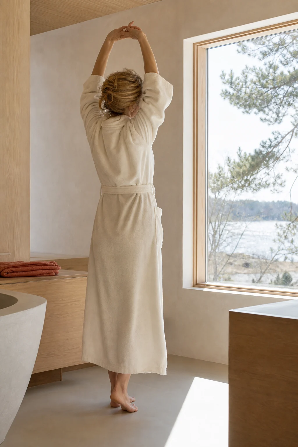 Woman stretching in a robe after bathing